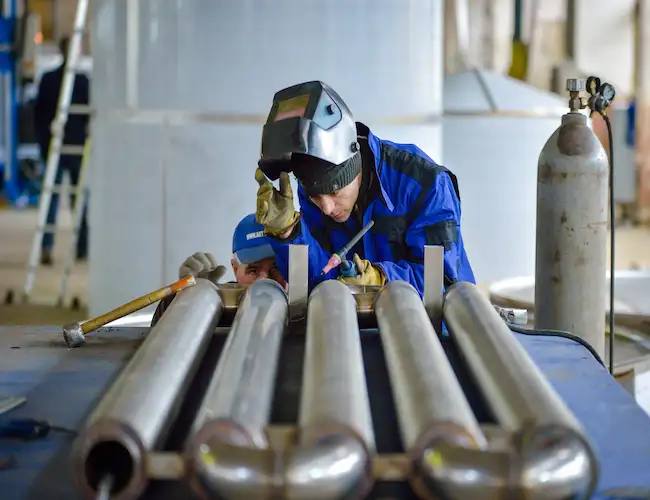 Técnico realizando soldadura TIG en depósitos alimentarios de acero inoxidable en bodega de la Comunidad Valenciana